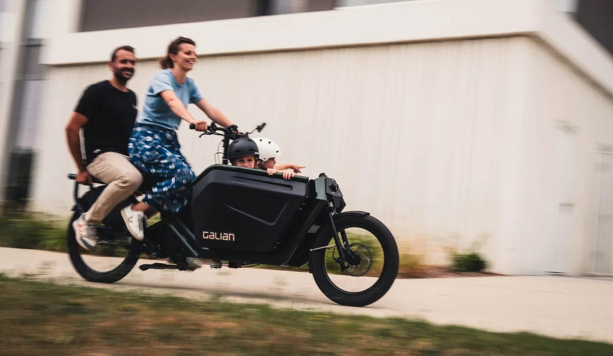 Vélo cargo Galian en mouvement, deux adultes et deux enfants à bord